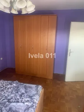 Spavaća soba sa velikim drvenim ormarom i krevetom. - image 7