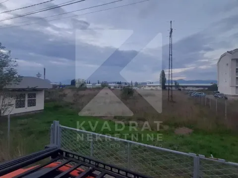 Pogled na plac sa niskim rastinjem i okolnim zgradama. - image 5