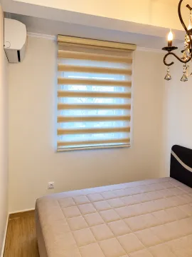 Bright bedroom with a double bed, window, and air conditioner. - image 5