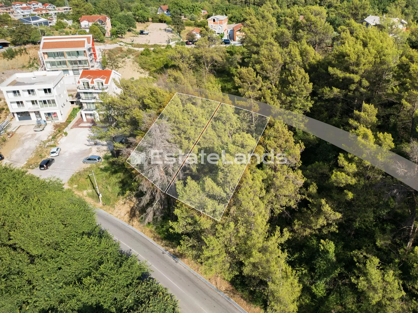 Iznadni pogled na šumovitu parcelu sa ucrtanim granicama i vodenim žigom agencije.