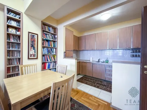 Dining area with a wooden table and chairs next to the fitted kitchen. - image 5