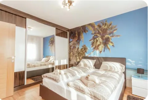 Furnished bedroom with a double bed, a large mirrored wardrobe, and a palm tree motif wallpaper. - image 8
