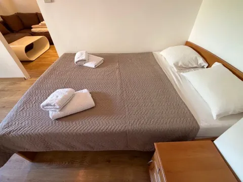 Furnished bedroom with a double bed and towels. - image 12