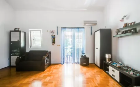 Living room with a sofa, wardrobes, and wooden flooring. - image 9