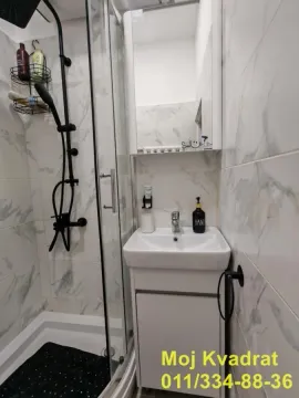 Kupatilo opremljeno tuš kabinom i umivaonikom sa ormarićem. - image 6
