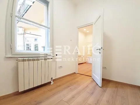 Empty room with laminate flooring, white walls, a window, and a door leading to another room. - image 7