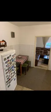 Kitchen with a dining table and a view into the living room. - image 16