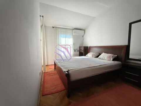 Spavaća soba sa bračnim krevetom, drvenim podom i ogledalom na zidu. - image 13