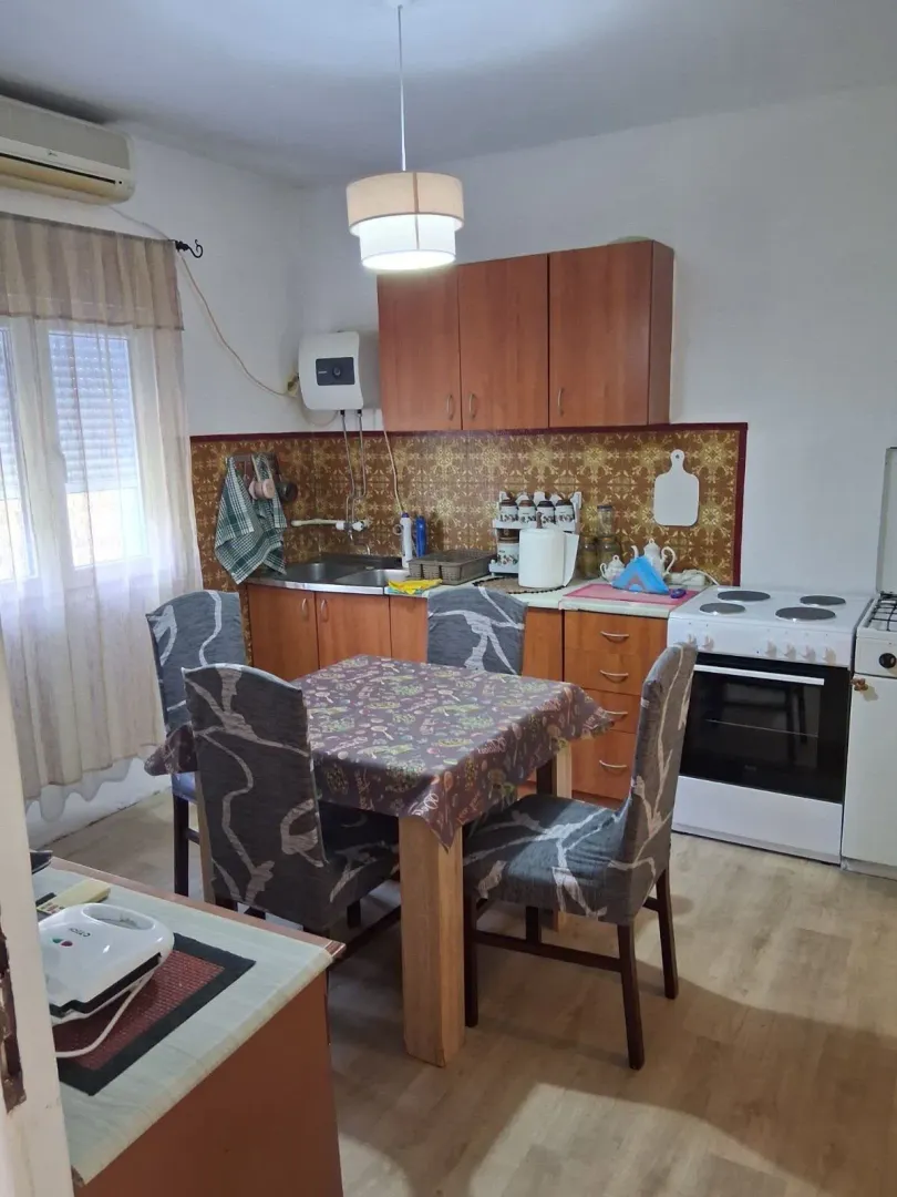 Kitchen with a dining table and wooden cabinets.