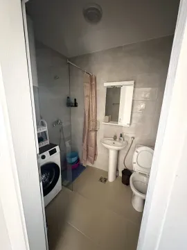 Kupatilo opremljeno tuš kabinom, umivaonikom, toaletom i veš mašinom. - image 6