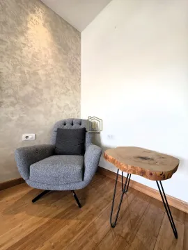 Ugao dnevne sobe sa foteljom i drvenim stočićem. - image 18