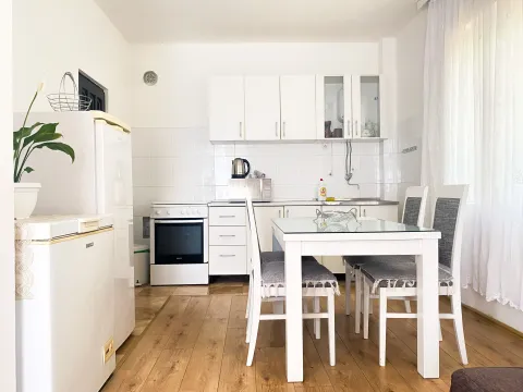 Small white kitchen with a dining table and chairs. - image 7