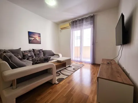 Dnevna soba sa garniturom, TV-om i izlazom na terasu. - image 3