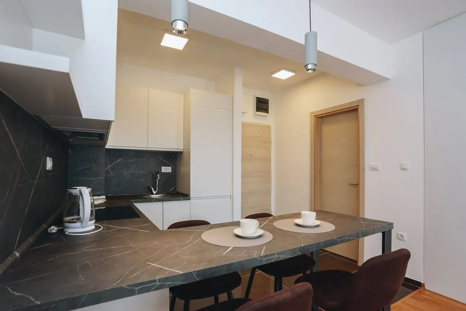 Modern kitchen with a bar counter and dining table.
