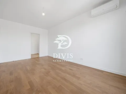 Prazna soba sa belim zidovima, drvenim parketom i klima uređajem. - image 7