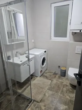 Savremeno opremljeno kupatilo sa tuš kabinom i veš mašinom. - image 3