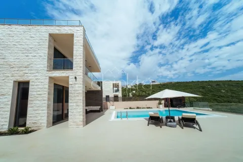 Modern villa with stone facade, swimming pool, and sun terrace. - image 6