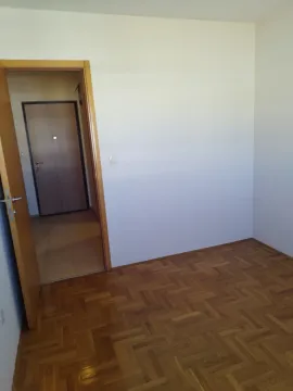 Prazna soba sa parketom i otvorenim vrata prema hodniku. - image 4