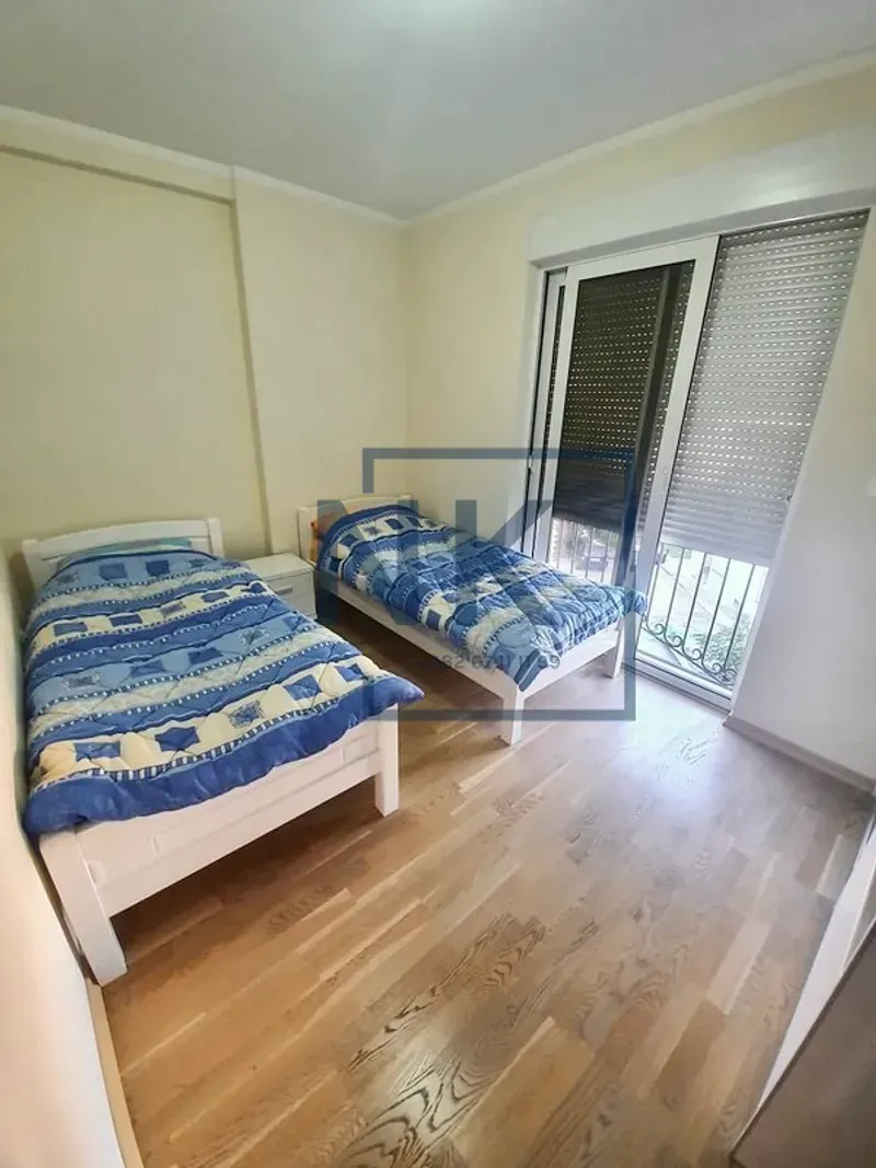 Spavaća soba sa dva kreveta za jednu osobu i izlazom na terasu.