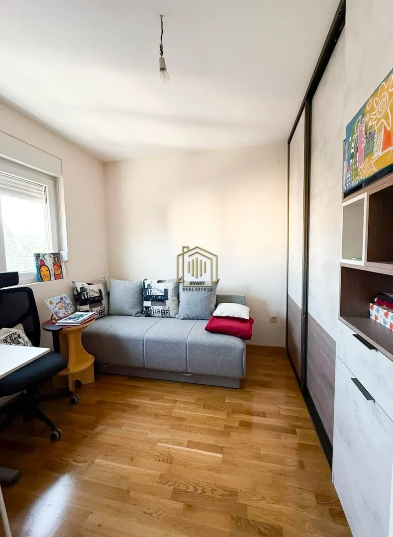 Smaller bedroom with a pull-out sofa and a built-in wardrobe.
