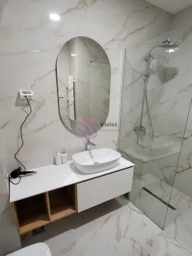 Modern bathroom with a sink, mirror, and walk-in shower. - image 13