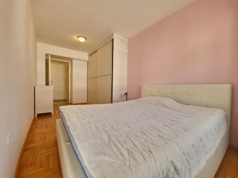 Bedroom with a large double bed, wardrobe, and parquet flooring. - image 21