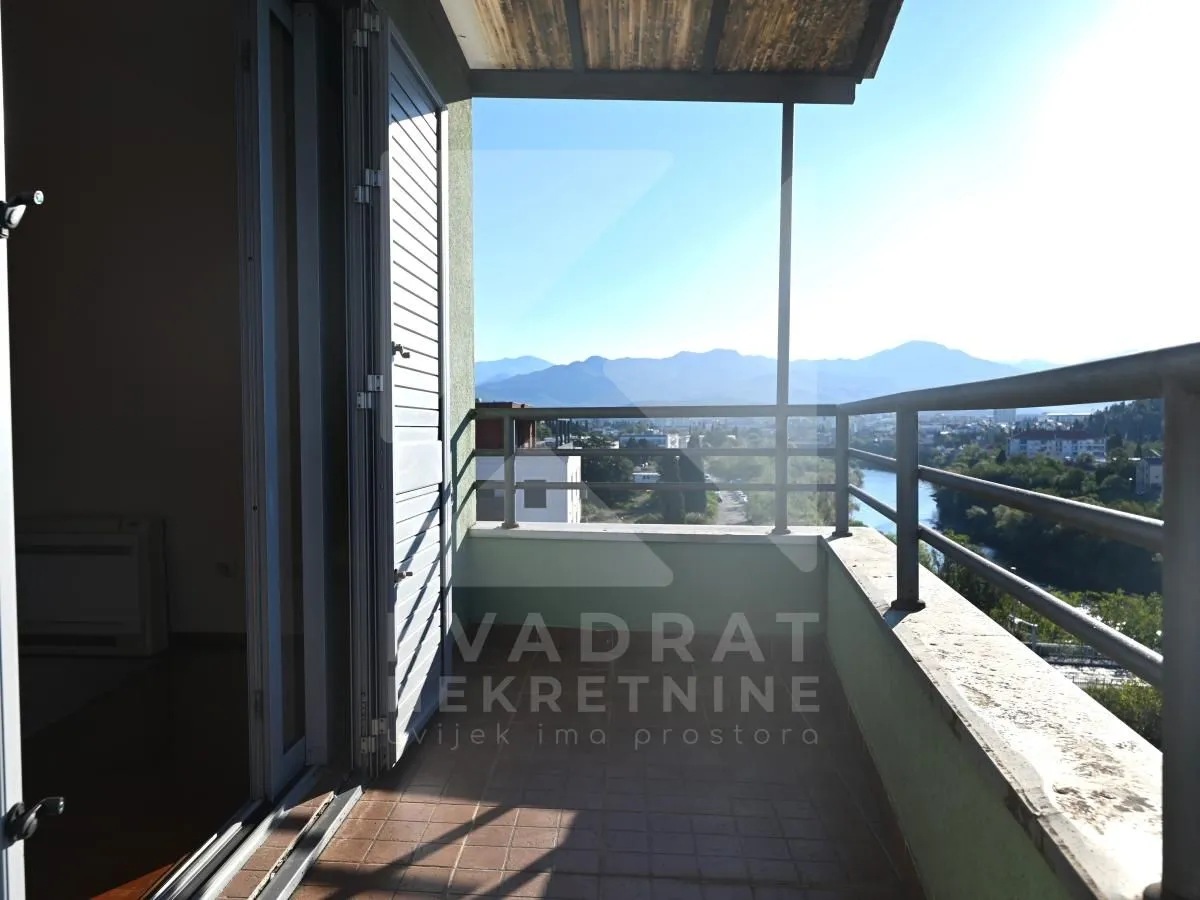 Covered balcony with a view of the river and mountains.
