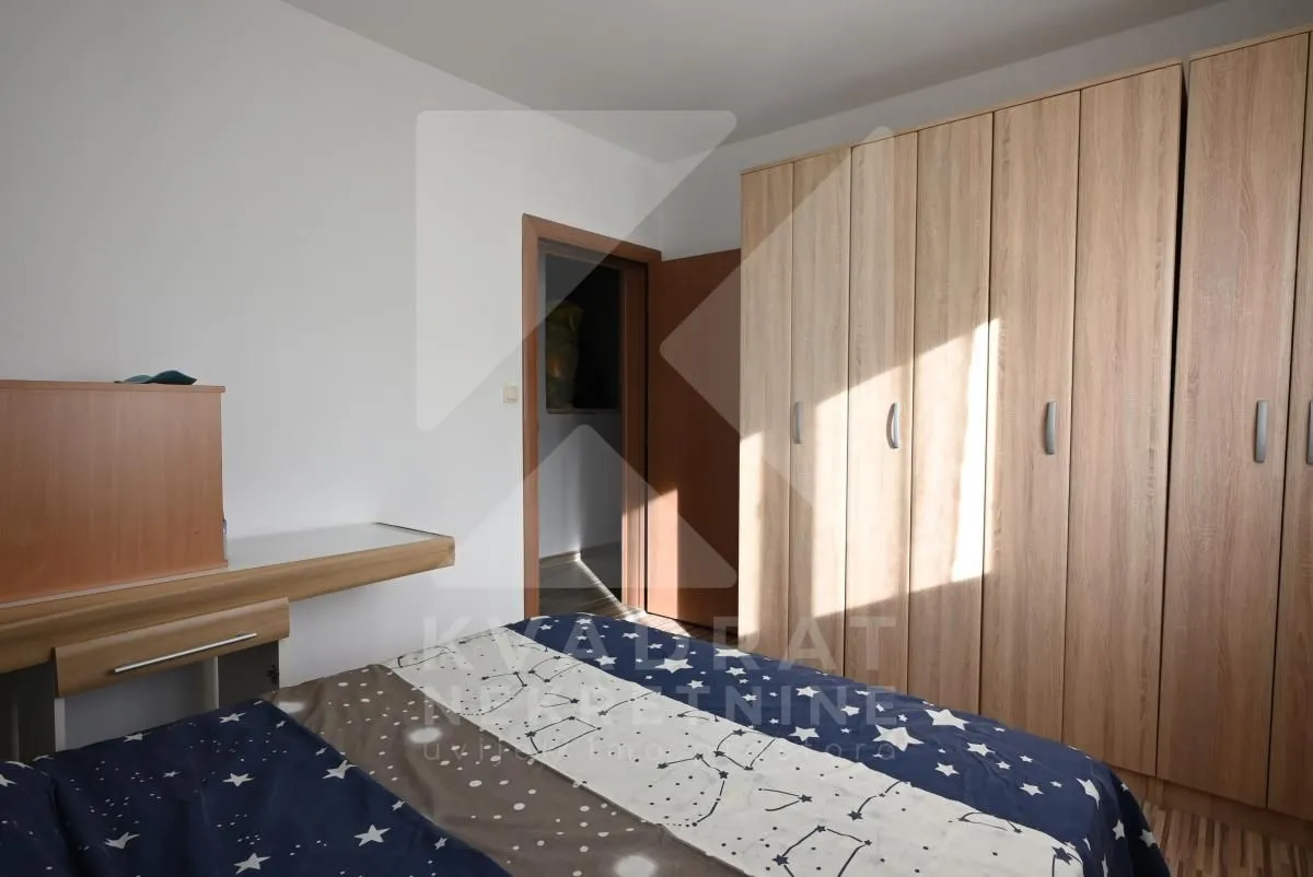 Bedroom with a bed, a large wooden wardrobe, and a desk.