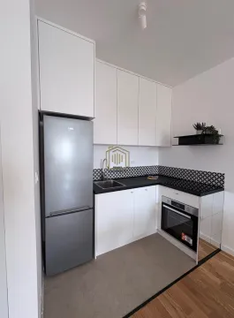 Manja bijela kuhinja sa crnom radnom površinom i ugradnim uređajima. - image 3