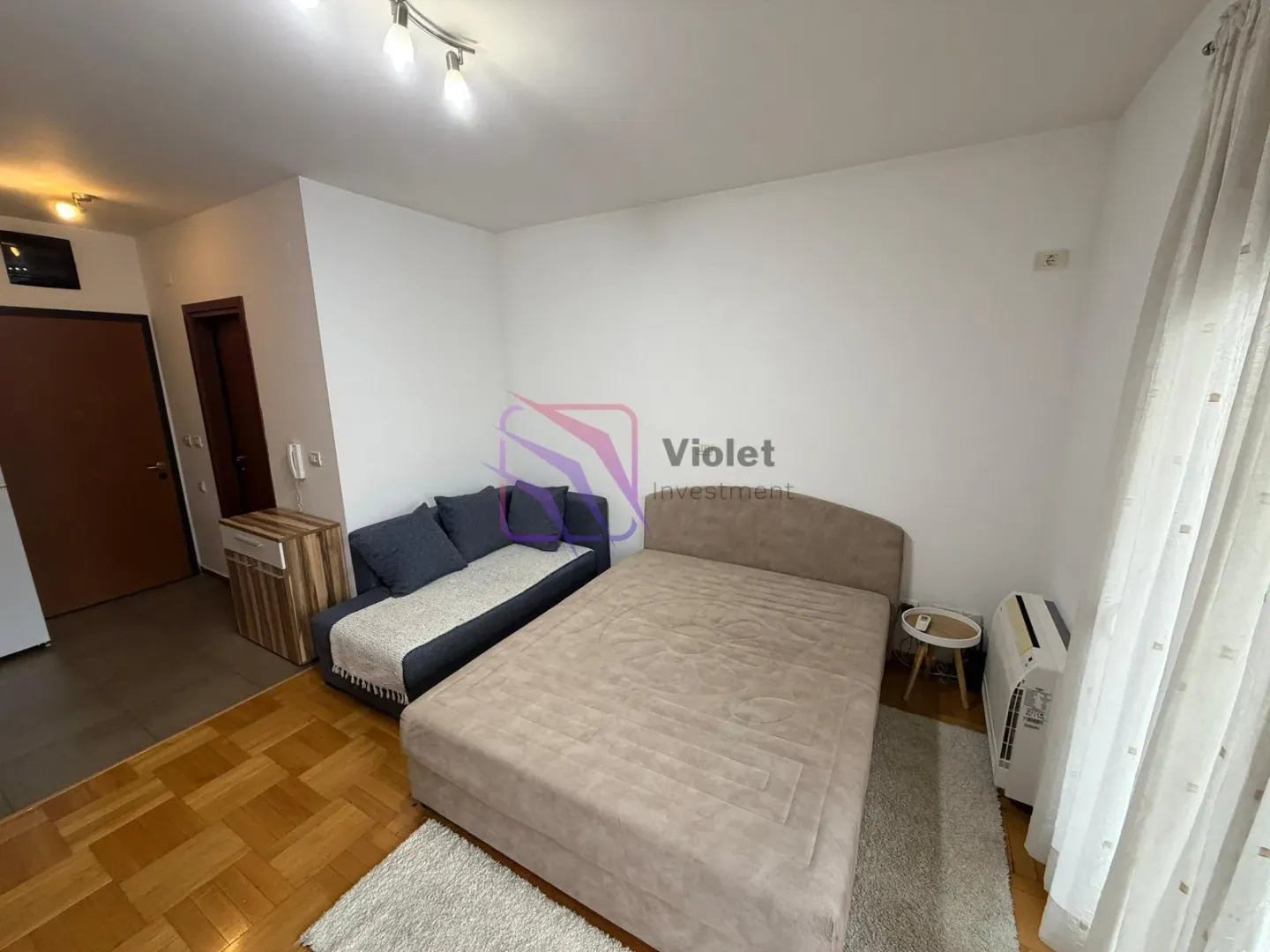 Bedroom with a double bed and a small sofa.