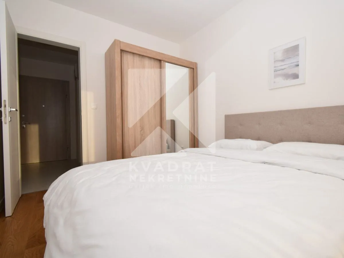 Bedroom with a double bed, wooden wardrobe, and white linens.
