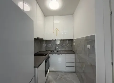 Moderna bijela kuhinja sa ugradnim elementima i mermernim pločicama. - image 12