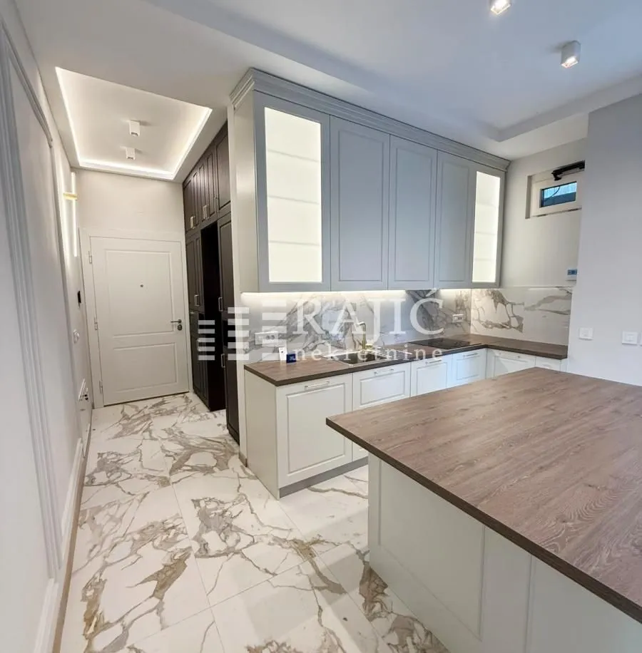 Modern kitchen with white cabinetry and a wooden countertop.