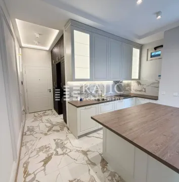 Modern kitchen with white cabinetry and a wooden countertop. - image 2
