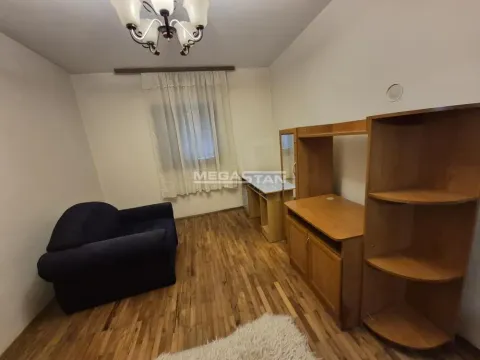 Nameštena spavaća soba sa drvenim nameštajem i foteljom. - image 3