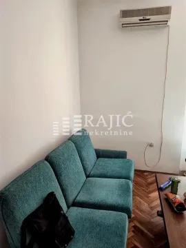 Living room with a green sofa and parquet flooring. - image 4