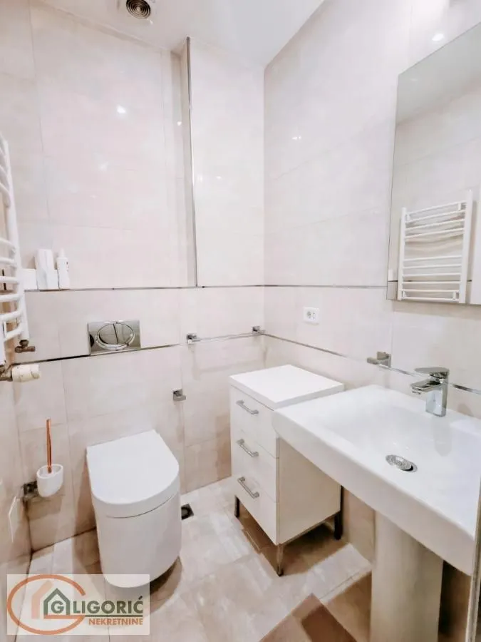 Compact bathroom with a sink, cabinet, and toilet.