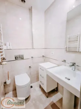 Compact bathroom with a sink, cabinet, and toilet. - image 6