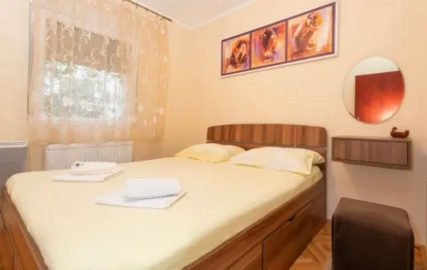 Furnished bedroom with a double bed, window, and artwork on the wall. - image 3