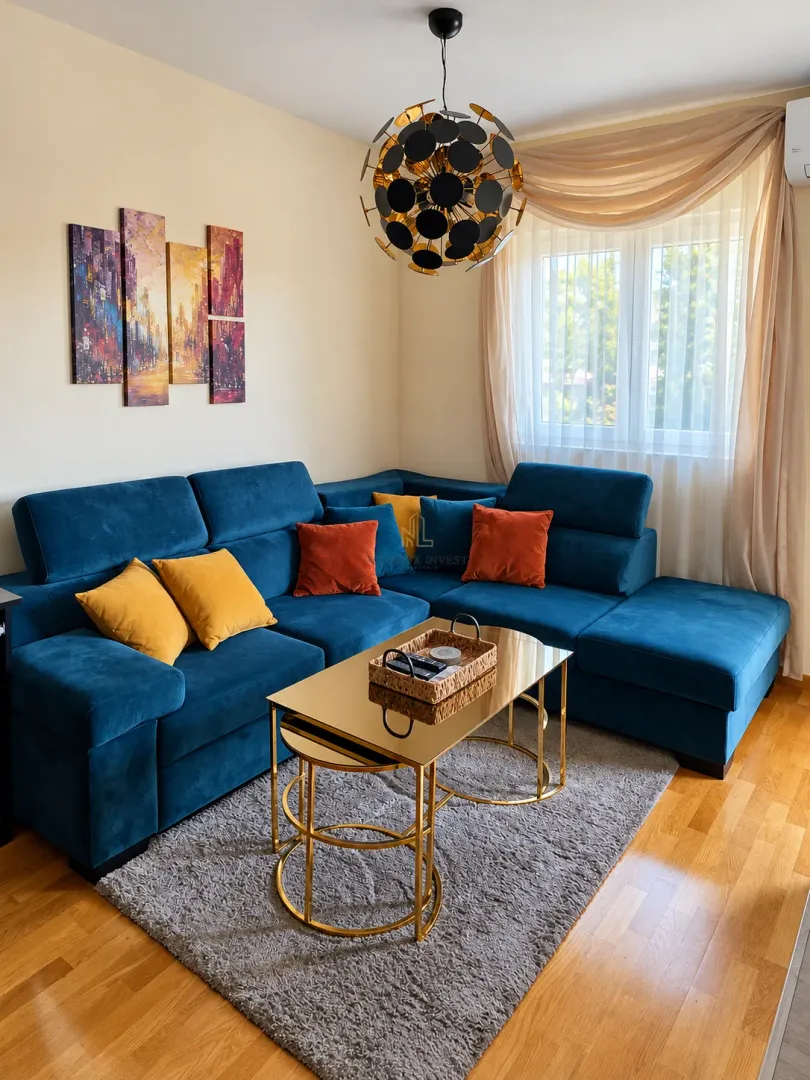 Dnevna soba sa plavom ugaonom garniturom, zlatnim stočićima i modernim lusterom.
