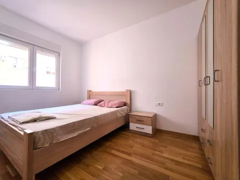 Svjetla spavaća soba sa bračnim krevetom, noćnim stočićem i ormarom. - image 11