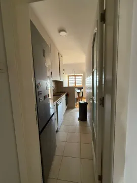 U uzkoj kuhinji nalaze se bijeli elementi i frižider. - image 12