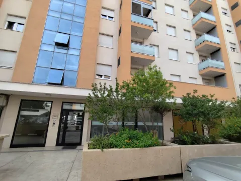 Facade of a residential building with an entrance and landscaped greenery in front. - image 2