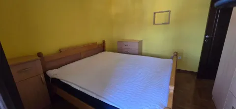 Spavaća soba sa bračnim krevetom i žutim zidovima. - image 7