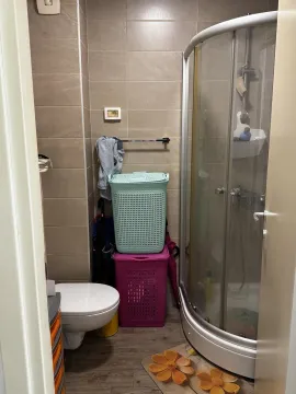 Kupatilo sa tuš kabinom, WC šoljom i korpama za veš. - image 6