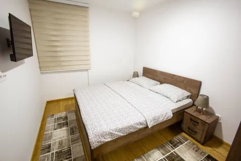 Bedroom with a double bed, nightstands, and a wall-mounted TV. - image 5