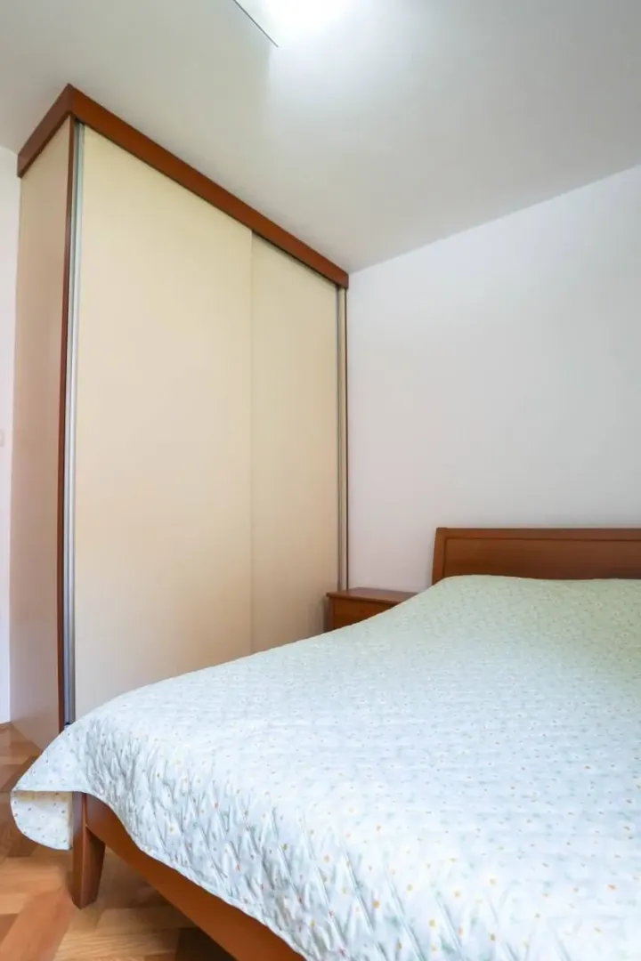 Tidy bedroom with a double bed and a fitted wardrobe.