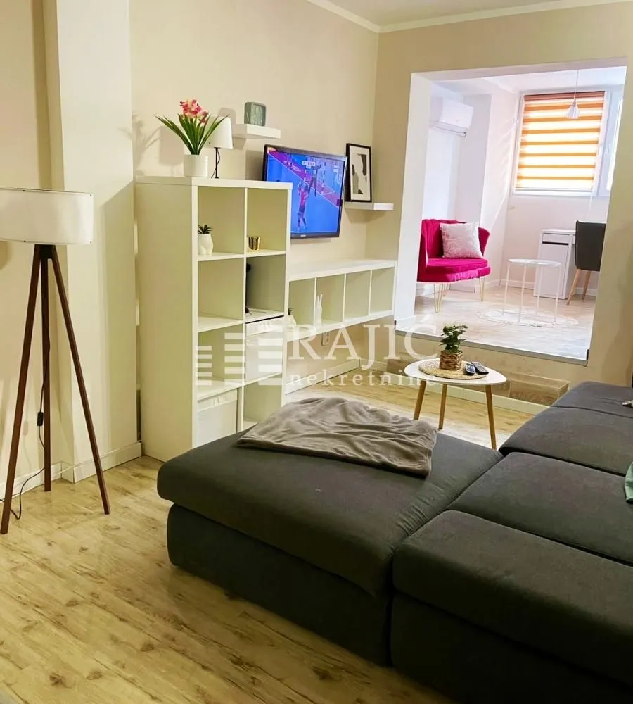 Living room with sofa and view of the dining area.