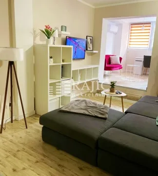 Living room with sofa and view of the dining area. - image 4