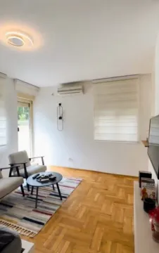 Dnevna soba sa garniturom za sedenje, stočićem i televizorom. - image 2